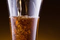 Stream in a beer glass on golden background.