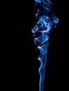 A stream of blue smoke twists into a spiral and rises up Royalty Free Stock Photo