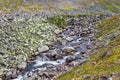 Stream cascades flowing over the rocks in the mountains