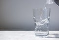 Stream of clean water pouring from a bottle into a glass with a splash Royalty Free Stock Photo