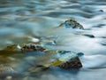 Stream flowing smoothly between rocks in the mountains Royalty Free Stock Photo