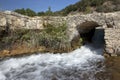 Stream flowing under a small stone bridge