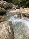 The stream flows between the boulders