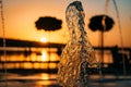 Stream of a fountain splashes water, sunset Royalty Free Stock Photo