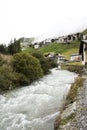 Stream and Glacier from Alps highest and most extensive mountain range flowing passed at Villages Royalty Free Stock Photo