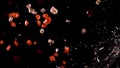 A stream of liquid flies in a frame with flying pieces of vegetables.