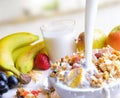 Stream of milk falling into a bowl of cereal and fruits Royalty Free Stock Photo