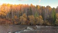 Stream of mountain river and fall forest. Autumn nature landscape at sunset