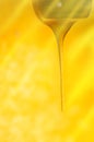 Stream of pouring honey. Honey flowing from a wooden honey spoon Royalty Free Stock Photo