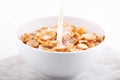 The stream of pouring milk in a bowl of muesli Royalty Free Stock Photo