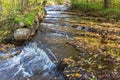 Stream and small waterfall at a stone wall Royalty Free Stock Photo