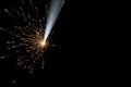 A stream of sparks with a bright beam of light on a black background. Space for text. Royalty Free Stock Photo