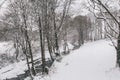 Stream surrounded by trees and roads covered in snow during storm Emma. Royalty Free Stock Photo