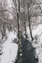 Stream surrounded by trees and roads covered in snow during storm Emma. Royalty Free Stock Photo