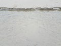 Stream of water at beach eroding sand and foot print Royalty Free Stock Photo