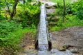 Stream of water flows in wooden gutter in the park