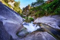 Stream of water between large eroded rocks.