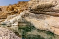 A stream of water in the rocky desert of Oman flowing in a canyon to the oasis of Wadi Bani Khalid - 4 Royalty Free Stock Photo