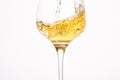 Stream of white wine flows into stem glass, swirls.