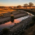 Stream winds through a landscape, reflecting the orange and pink hues Royalty Free Stock Photo