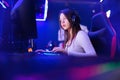 Streamer beautiful girl professional gamer smile playing online games computer with headphones, neon color