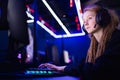 Streamer beautiful girl professional gamer smile playing online games computer with headphones, neon color