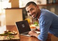 Streaming my favourite chefs cooking tutorials. Portrait of a happy young man using a laptop while preparing a healthy Royalty Free Stock Photo