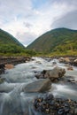 Streams and rocks between mountains with blue sky and green trees Royalty Free Stock Photo