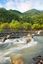 Streams and rocks between mountains with blue sky and green trees Royalty Free Stock Photo