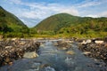 Streams and rocks between mountains with blue sky and green trees Royalty Free Stock Photo