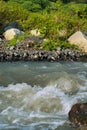 Streams and rocks between mountains with blue sky and green trees Royalty Free Stock Photo