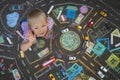 Streat portrait of the toddler playing cars in the chalk drawn city