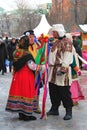 Street actors in colorful national costumes stand on the street.