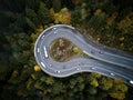 Street from above trough a misty forest at autumn, aerial view flying through the clouds with fog and trees Royalty Free Stock Photo