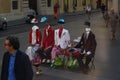 Street actors dressed as sitting figures with no heads and floating Fedoras, work for tips on a street corner in Rome