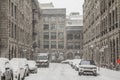 Street Alley of Old-Montreal in winter under a snow storm with a modern skyscraper in the background