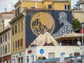 Street art of a black silhouette dressed in stars looking at a sphere to Rome in Italy. 