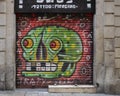 Street art graffiti style on a garage type roll down door for a tattoo piercing business in Barcelona, Spain.