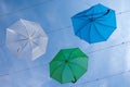 Street art with hanging blue, green and white umbrellas