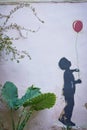 Street art on a Morocco street with a boy holding a red  ballon Royalty Free Stock Photo