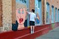 Street art on Oktyabrskaya street, Minsk, Belarus. Man draws graffiti on wall of industrial building