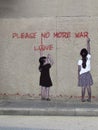 Street art with two girls writing Please no more war