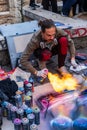 A street artist demonstrates art creation using paint spray cans and fire in Athens city centre