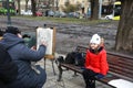 Street artist drawing a caricature of a couple in Lviv