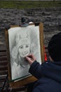 Street artist drawing a caricature of a couple in Lviv