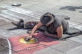 Street artist drawing on the pavement with chalk