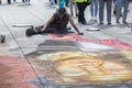 Street artist draws on the pavement with chalk