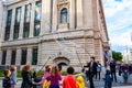 Street artist dressed like British gentleman in black costume with hat cylinder performing for the kids blowing huge soap bubbles