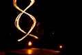 Street artist fire juggling performance. Light painting and long exposure picture to form trails. Phi Phi Island, Thailand.