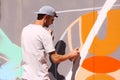 Street artist painting colorful graffiti on wall - Modern art concept with urban guy painting live murales with aerosol color spra Royalty Free Stock Photo